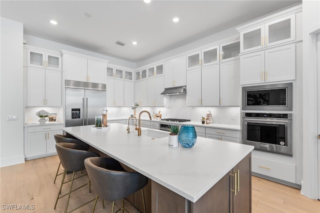16214 Verilyn Cir, Naples, FL 34110 - kitchen with built in appliances, a sink, visible vents, and light wood-style flooring