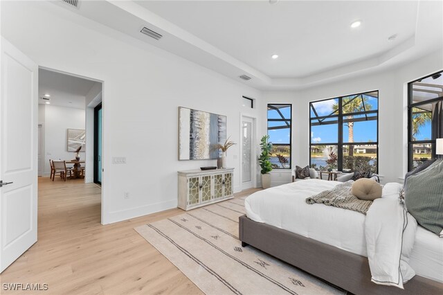 16214 Verilyn Cir, Naples, FL 34110 - bedroom featuring light wood-style flooring, a raised ceiling, baseboards, visible vents, and recessed lighting