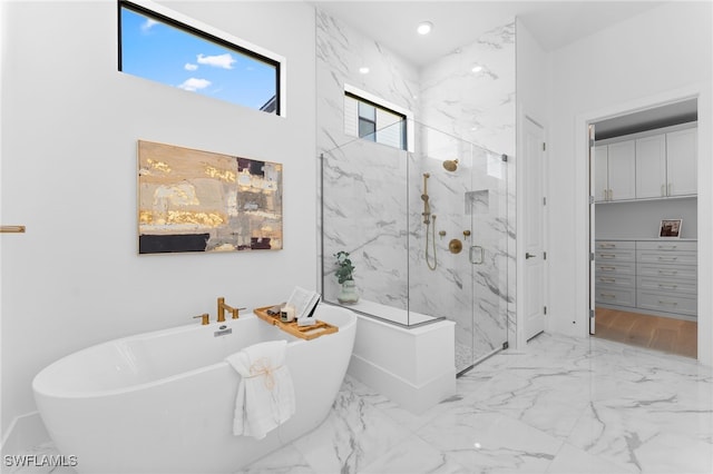 16214 Verilyn Cir, Naples, FL 34110 - bathroom with a soaking tub, baseboards, marble finish floor, and a marble finish shower