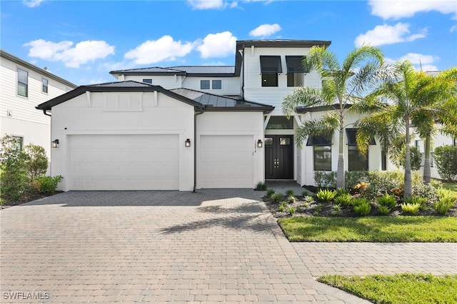 16214 Verilyn Cir, Naples, FL 34110 - view of front of home featuring a garage, stucco siding, a standing seam roof, decorative driveway, and metal roof