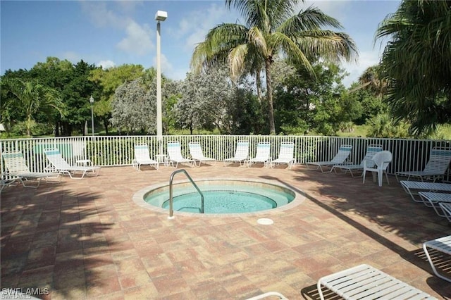 view of pool featuring fence, a hot tub, and a patio area