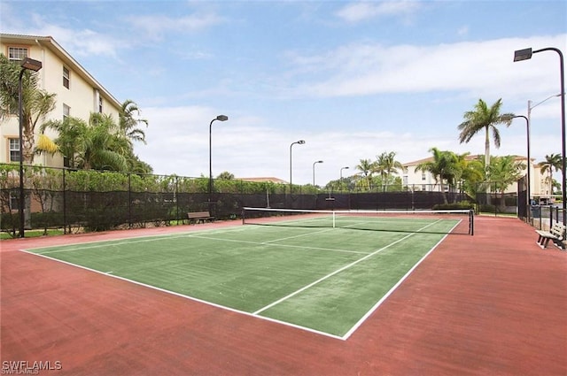 view of tennis court featuring fence and community basketball court