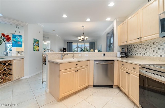 kitchen with ornamental molding, decorative backsplash, a peninsula, appliances with stainless steel finishes, and a notable chandelier