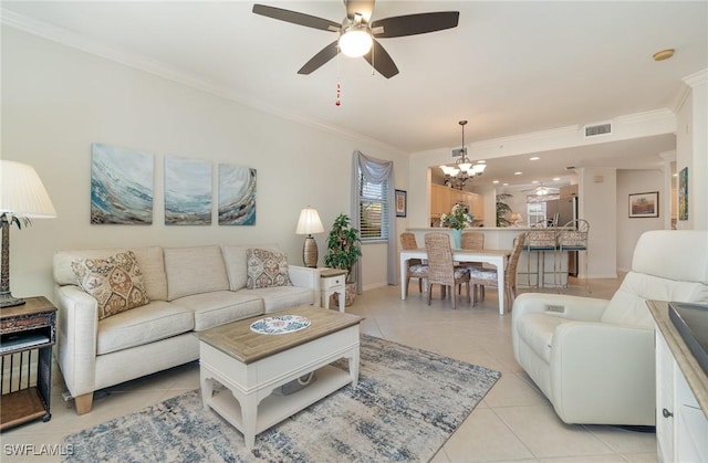 living area with visible vents, crown molding, baseboards, ceiling fan with notable chandelier, and light tile patterned flooring
