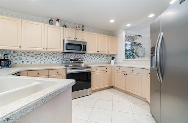 kitchen with light countertops, appliances with stainless steel finishes, light tile patterned floors, and backsplash