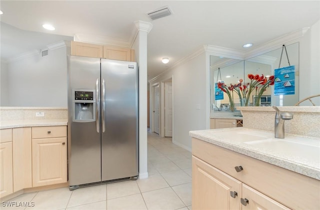 kitchen featuring stainless steel refrigerator with ice dispenser, light countertops, crown molding, and light brown cabinetry