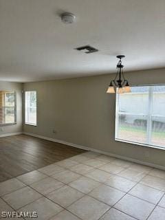 18301 Pine Nut Ct, Lehigh Acres, FL 33972 - empty room with baseboards, a notable chandelier, light tile patterned floors, and visible vents