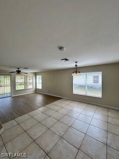 18301 Pine Nut Ct, Lehigh Acres, FL 33972 - interior space with baseboards, tile patterned flooring, and ceiling fan with notable chandelier