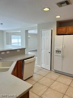 18301 Pine Nut Ct, Lehigh Acres, FL 33972 - kitchen featuring a sink, white appliances, brown cabinetry, light tile patterned floors, and visible vents