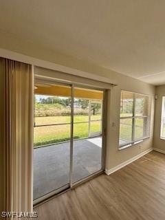 18301 Pine Nut Ct, Lehigh Acres, FL 33972 - entryway with baseboards and wood finished floors
