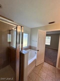 18301 Pine Nut Ct, Lehigh Acres, FL 33972 - bathroom featuring tile patterned floors, a stall shower, a garden tub, and visible vents