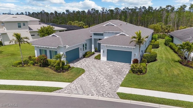view of front facade featuring a garage, a front lawn, a tiled roof, and decorative driveway