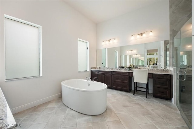 full bathroom with a shower stall, tile patterned flooring, vanity, baseboards, and a soaking tub