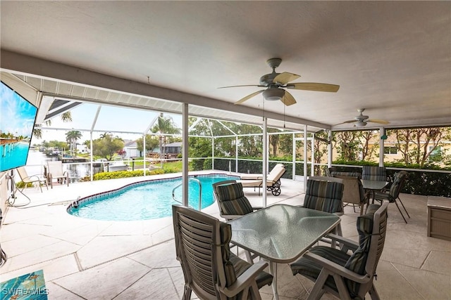 pool with a patio area, a lanai, outdoor dining area, and ceiling fan