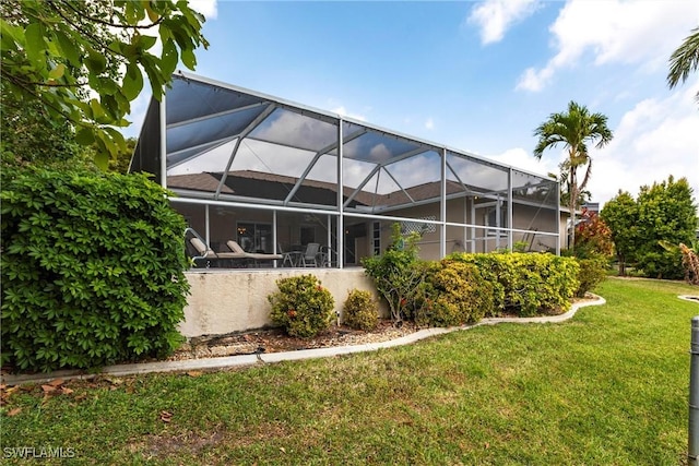 back of house featuring a yard and a lanai