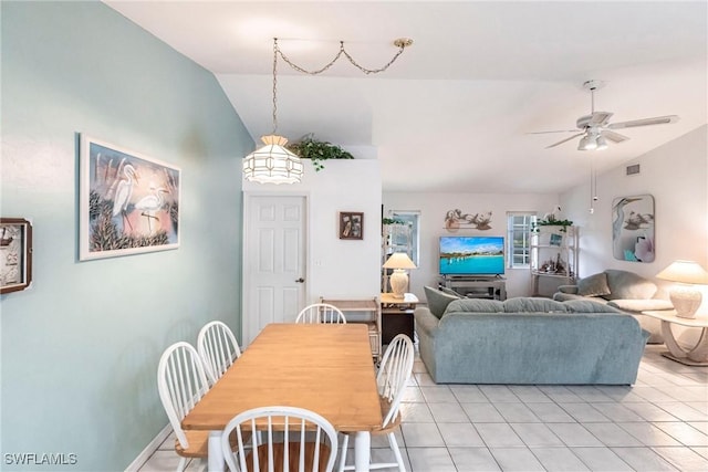 dining space featuring lofted ceiling, visible vents, light tile patterned floors, baseboards, and ceiling fan