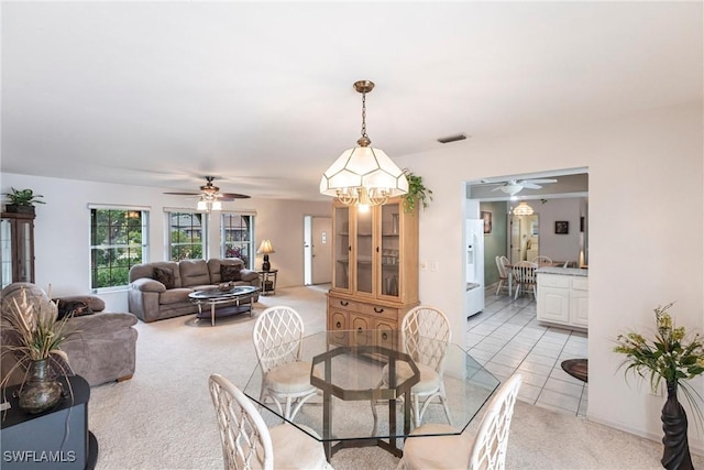 dining room featuring visible vents, a ceiling fan, and light carpet