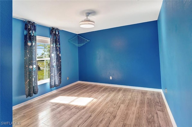 empty room featuring baseboards and wood finished floors