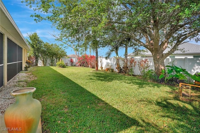 view of yard with a fenced backyard and a sunroom