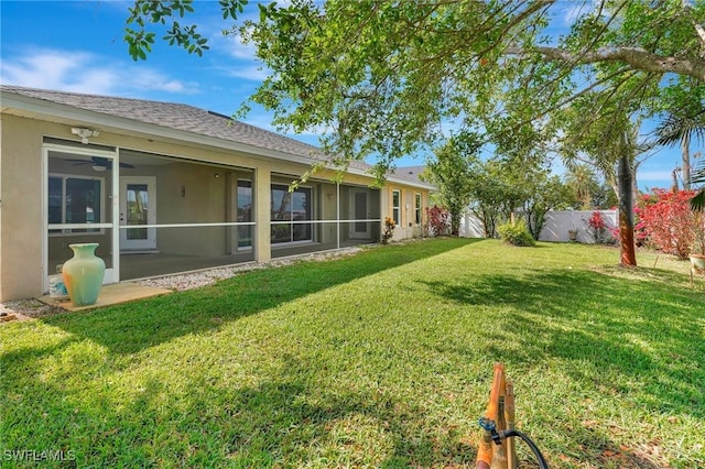 view of yard with ceiling fan and fence