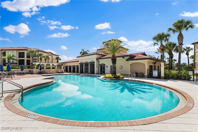 community pool featuring a patio area and fence