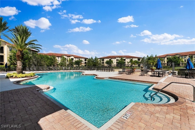 community pool with fence and a patio area