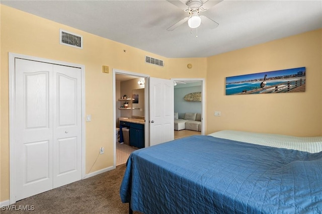carpeted bedroom featuring baseboards, a ceiling fan, visible vents, and connected bathroom