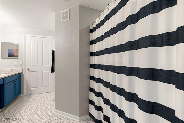 full bathroom with baseboards, a shower with curtain, vanity, and visible vents