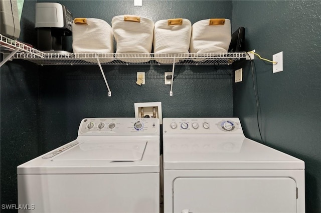 laundry area featuring independent washer and dryer, a textured wall, and laundry area