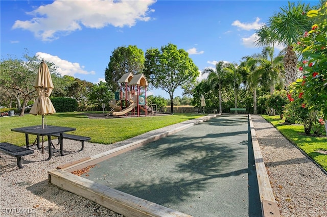 view of property's community with playground community and a yard