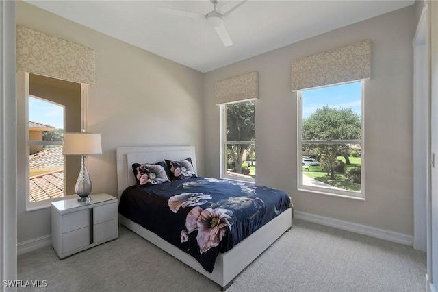bedroom featuring baseboards, ceiling fan, and light colored carpet