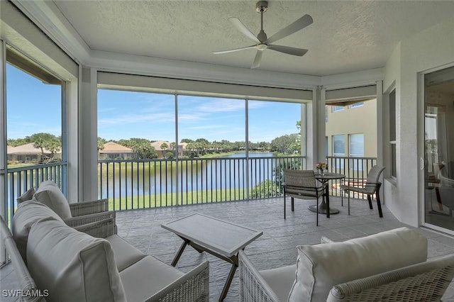sunroom featuring a water view and a textured ceiling