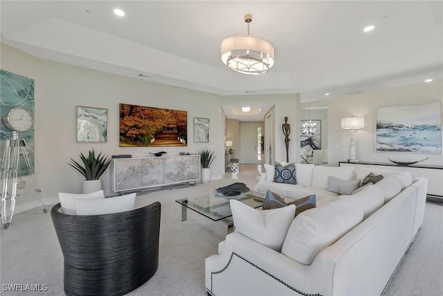 carpeted living room with recessed lighting, baseboards, visible vents, and a tray ceiling