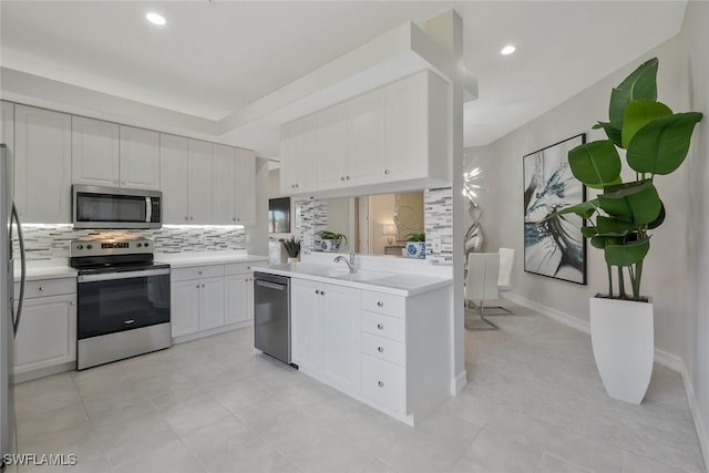 kitchen featuring light countertops, white cabinetry, appliances with stainless steel finishes, and backsplash