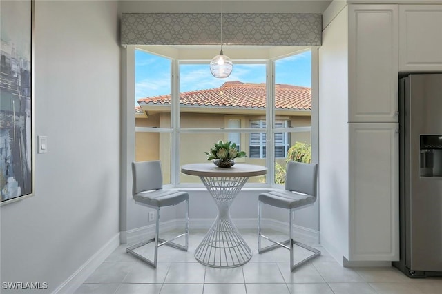 dining room with light tile patterned floors and baseboards