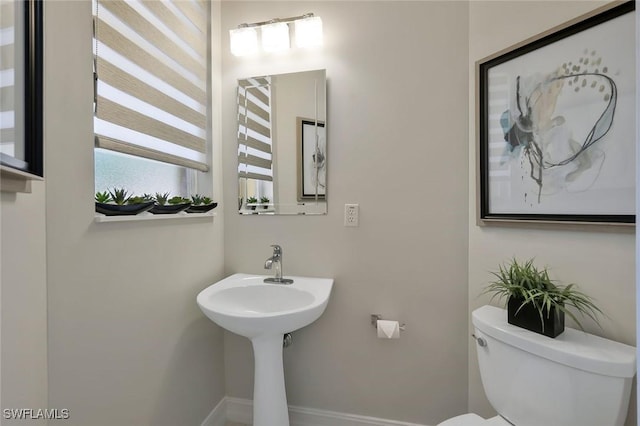 bathroom featuring toilet and baseboards