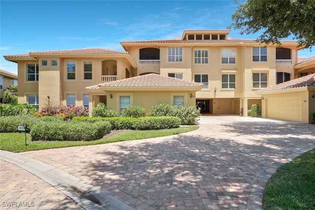 view of front of property with a garage, decorative driveway, stucco siding, and a tile roof
