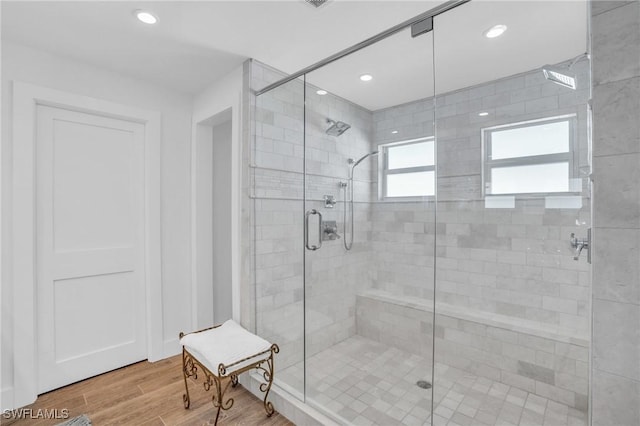 bathroom with recessed lighting, wood finished floors, and a stall shower