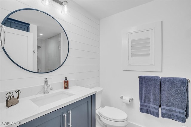 bathroom featuring a shower stall, toilet, and vanity