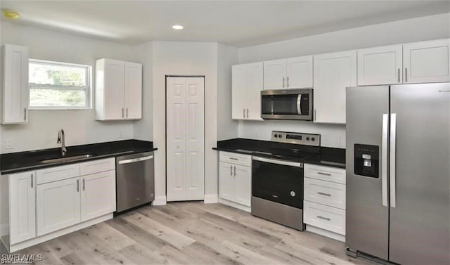 4637 Elvas Ave S, Fort Myers, FL 33905 - kitchen featuring stainless steel appliances, a sink, recessed lighting, white cabinets, and light wood-type flooring