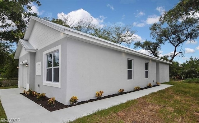 4637 Elvas Ave S, Fort Myers, FL 33905 - view of side of home featuring stucco siding and a garage