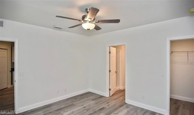 4637 Elvas Ave S, Fort Myers, FL 33905 - unfurnished bedroom with wood finished floors, a closet, baseboards, a spacious closet, and ceiling fan