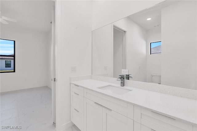3101 NW 42nd Pl, Cape Coral, FL 33993 - bathroom with marble look tile flooring, vanity, toilet, a ceiling fan, and recessed lighting