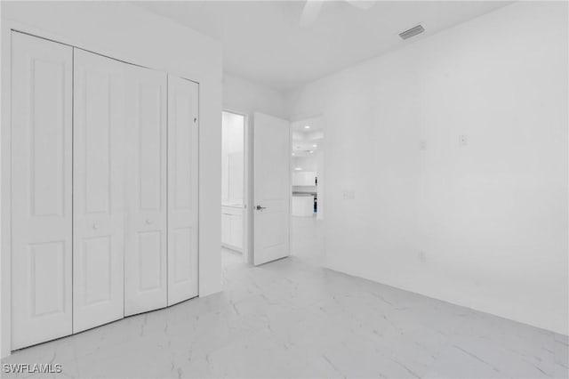 3101 NW 42nd Pl, Cape Coral, FL 33993 - unfurnished bedroom with light marble finish floors, a closet, and a ceiling fan
