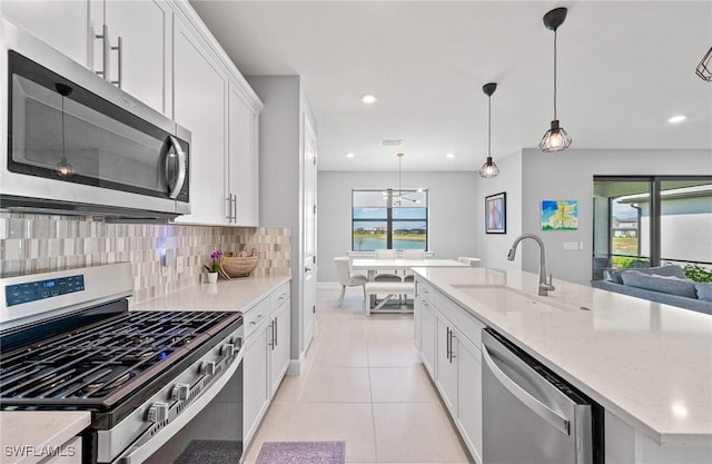 20250 Napa Loop, Estero, FL 33928 - kitchen with white cabinets, a sink, light tile patterned floors, decorative backsplash, and appliances with stainless steel finishes