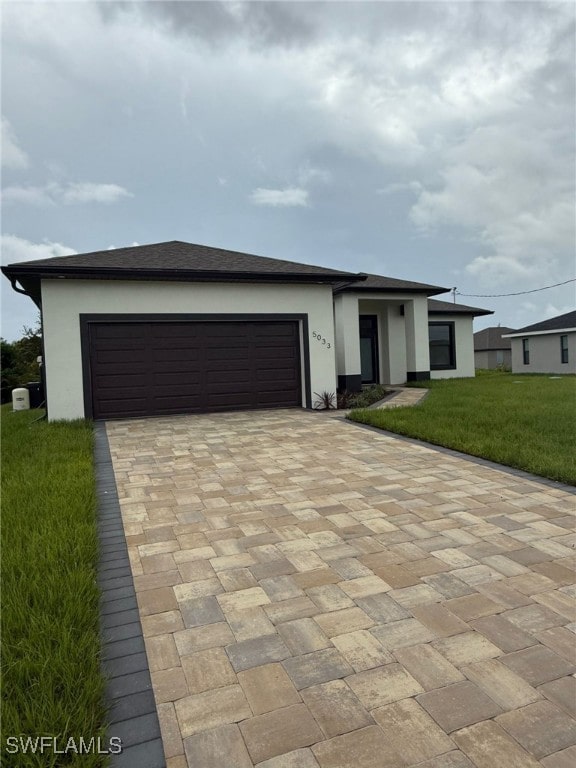 5033 Bristo St, Lehigh Acres, FL 33971 - prairie-style home with decorative driveway, stucco siding, an attached garage, and a front yard
