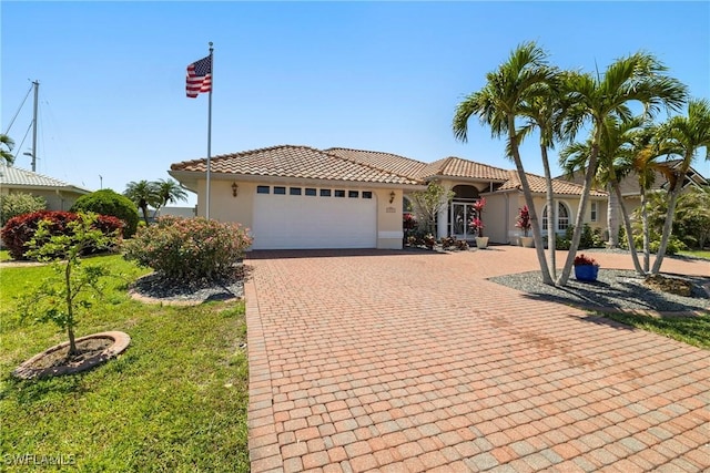 2817 La Mancha Ct, Punta Gorda, FL 33950 - mediterranean / spanish-style home with a garage, stucco siding, decorative driveway, and a tile roof
