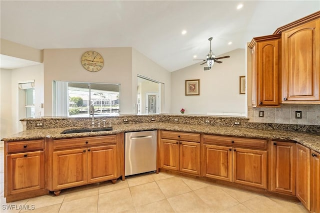 2817 La Mancha Ct, Punta Gorda, FL 33950 - kitchen featuring stainless steel dishwasher, ceiling fan, dark stone countertops, brown cabinets, and vaulted ceiling