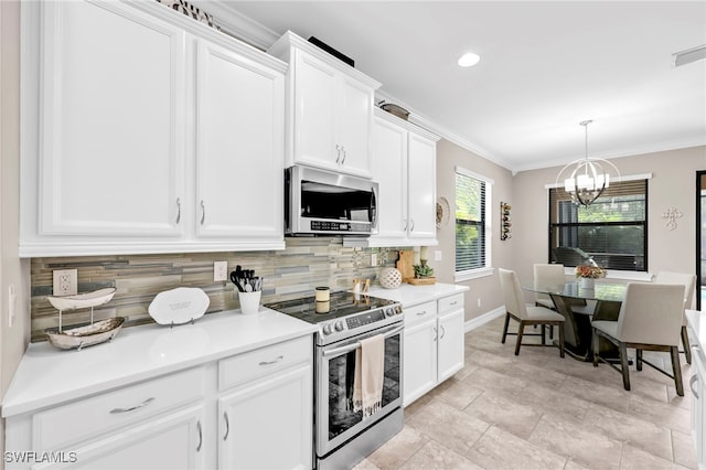 14482 Tuscany Pointe Trl, Naples, FL 34120 - kitchen featuring stainless steel appliances, decorative backsplash, a chandelier, white cabinets, and ornamental molding
