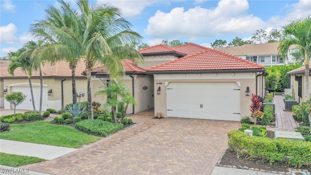 14482 Tuscany Pointe Trl, Naples, FL 34120 - mediterranean / spanish home with stucco siding, a garage, decorative driveway, and a tiled roof